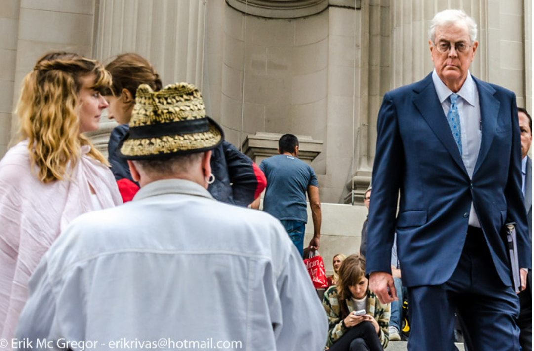 In September 2014, energy magnate David H. Koch passed by protesters on the Metropolitan Museum of Art’s plaza, which had been recently renamed in his honor. The demonstration, held by Occupy Museums, denounced the Met’s involvement with Koch, who underwrote the full &dollar;65 million cost of the redesign and renovation of the plaza fronting New York’s premier art institution. One of the owners of the largest privately run energy company in the United States, Koch and his brother Charles financed for decades deregulation, anti-government, and anti-union candidates, legislation, and movements such as the Tea Party. Along with other giant businesses and corporations, the Kochs masked their business practices and political influence through philanthropy, especially in heavily publicized donations to major cultural institutions.